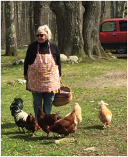 A person holding a basket with chickens  Description automatically generated