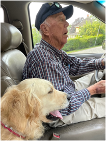 A person and dog in a car
Description automatically generated