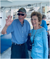 A person and person standing on a boat
Description automatically generated