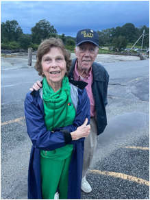 A person and person standing on a road
Description automatically generated